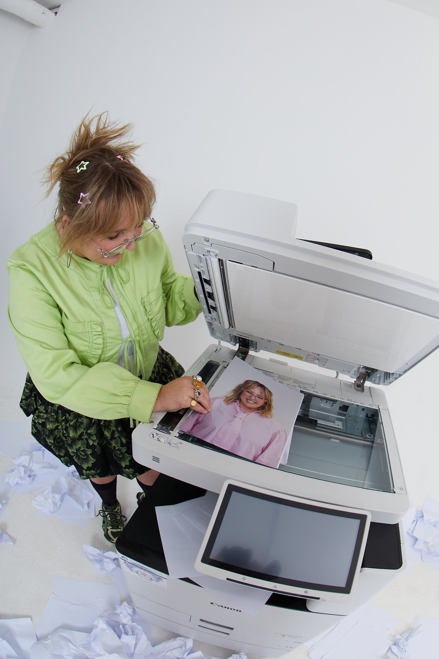 Person using a large scanner with a photo on a white background